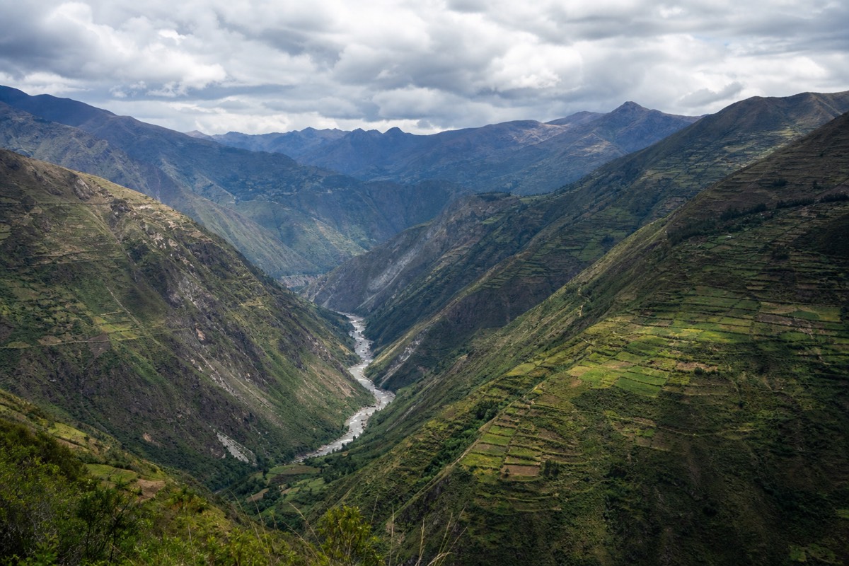 Sweeping view over a green Peruvian valley toward distant mountains